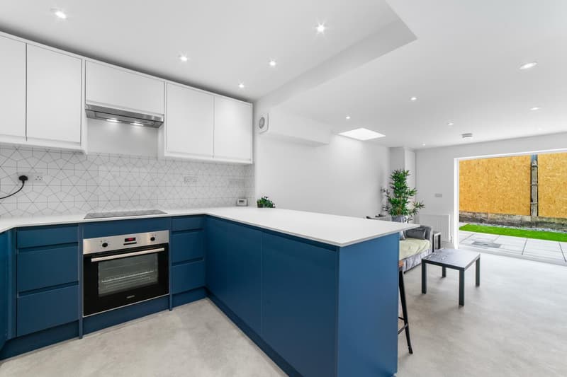 L-shaped open-plan kitchen with integrated oven and doors to the garden in a Cathays HMO