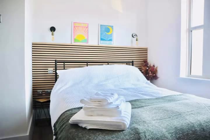 Large bedroom with slatted headboard wall
