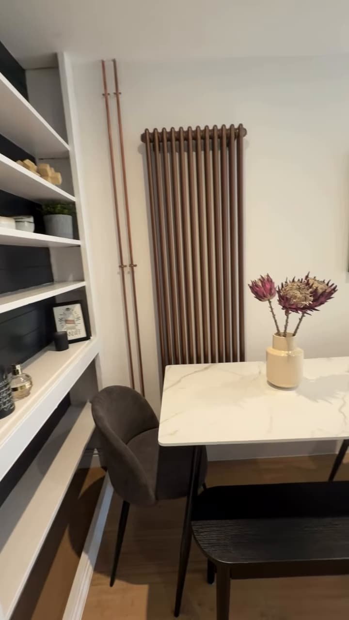 Dining nook with marble-top table, built-in shelving and tall column radiator