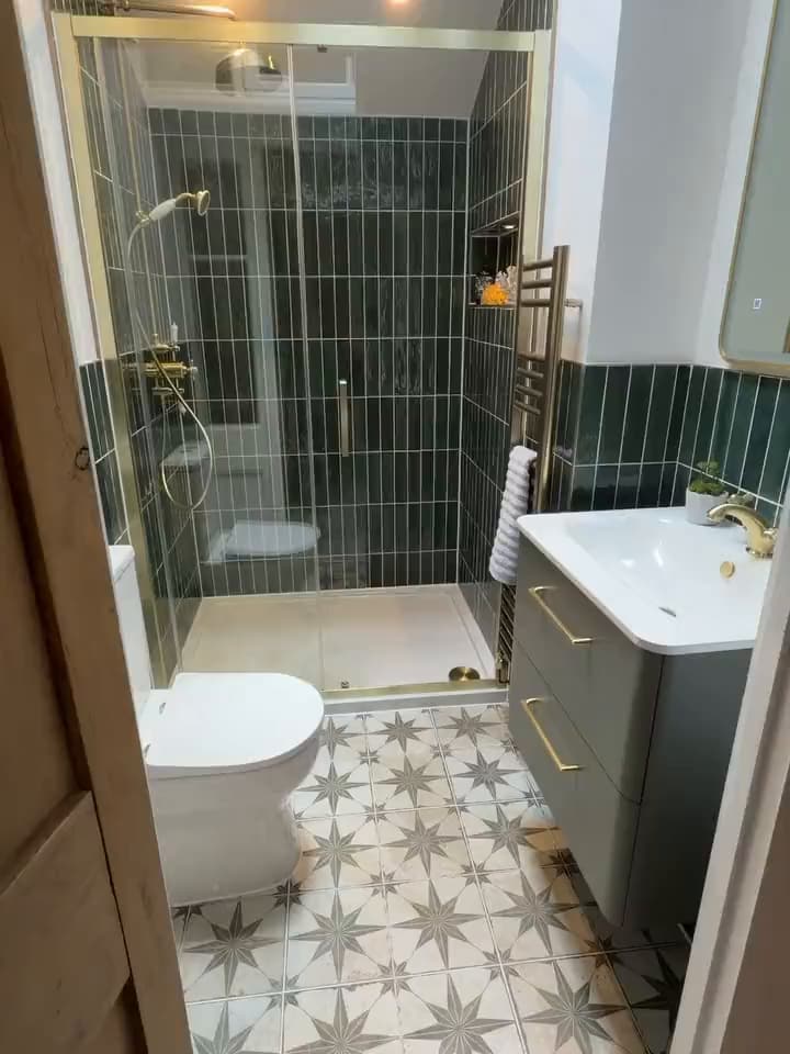 Close look at the hotel-style en-suite with green tiles and brass fittings