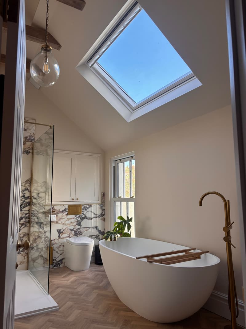 Walk-in shower beside a freestanding stone bath under the skylight in a Pontcanna loft bathroom