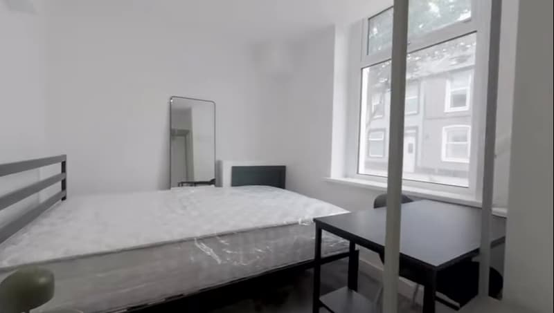 Student bedroom with double bed and desk by the window