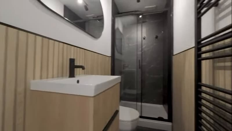 Shower room with oak slat panelling, black taps and walk-in shower